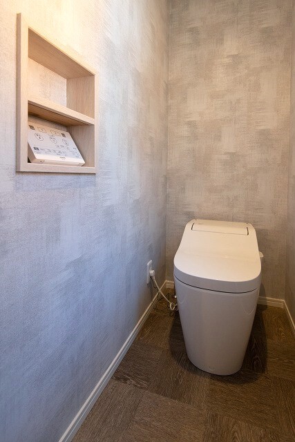 塗り壁調のクロス+木目の床のトイレ