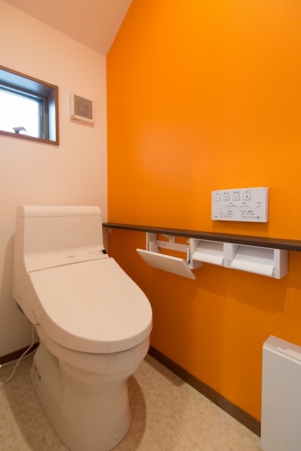 ビタミンカラーのオレンジのクロスが鮮やかなトイレ