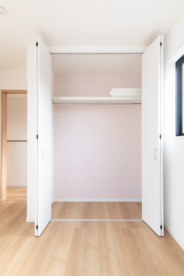 川崎市麻生区の注文住宅 収納と生活動線を考慮した家 クローゼットとピンクのリボン柄のクロス